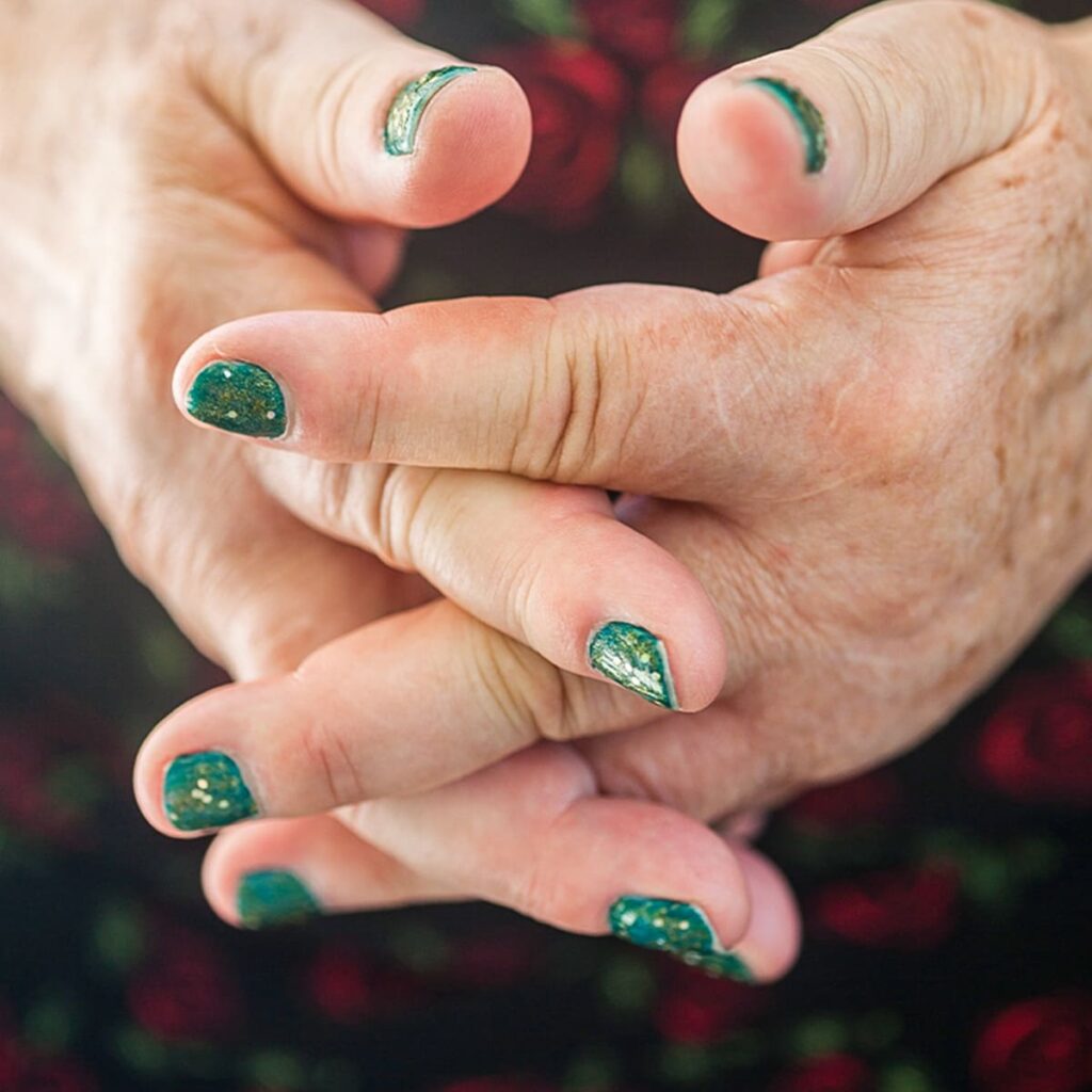 緑色のネイルをしている手元